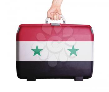 Used plastic suitcase with stains and scratches, printed with flag, Syria
