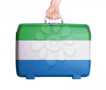 Used plastic suitcase with stains and scratches, printed with flag, Sierra Leone