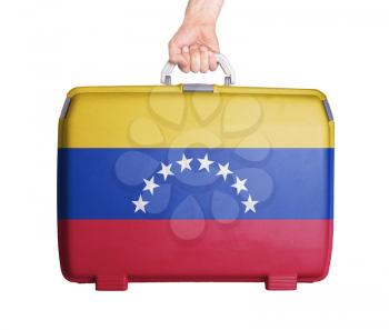 Used plastic suitcase with stains and scratches, printed with flag, Venezuela
