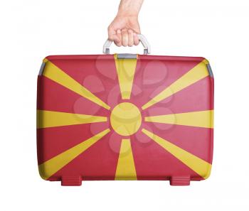 Used plastic suitcase with stains and scratches, printed with flag, Macedonia