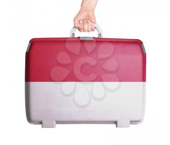 Used plastic suitcase with stains and scratches, printed with flag, Monaco