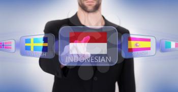 Hand pushing on a touch screen interface, choosing language or country, Indonesia