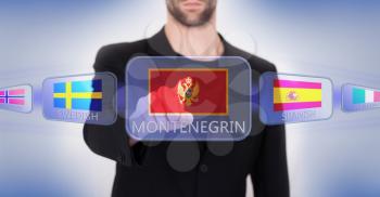 Hand pushing on a touch screen interface, choosing language or country, Montenegro