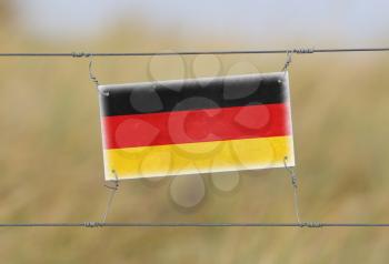 Border fence - Old plastic sign with a flag - Germany
