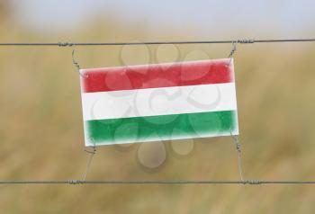 Border fence - Old plastic sign with a flag - Hungary