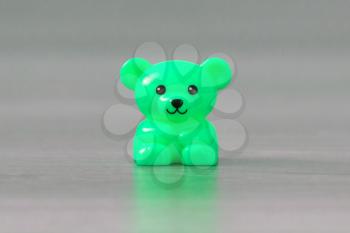 Small green bear on a wooden floor