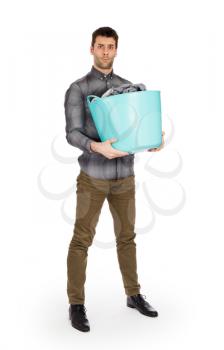 Full length portrait of a young man holding a laundry basket isolated on white background