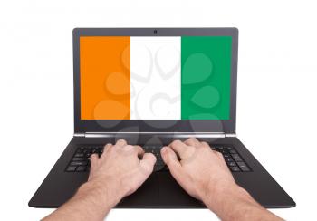 Hands working on laptop showing on the screen the flag of Ireland