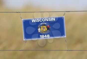 Border fence - Old plastic sign with a flag - Wisconsin