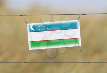 Border fence - Old plastic sign with a flag - Uzbekistan