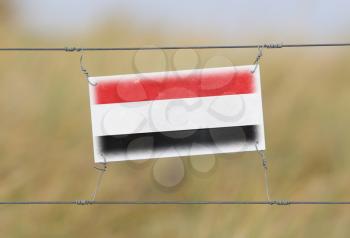 Border fence - Old plastic sign with a flag - Yemen