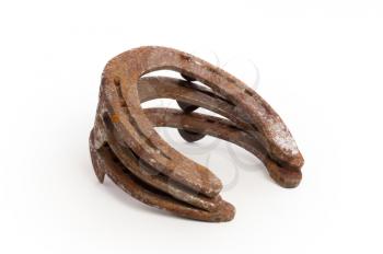 Stack of old rusty horseshoes, isolated on a white background