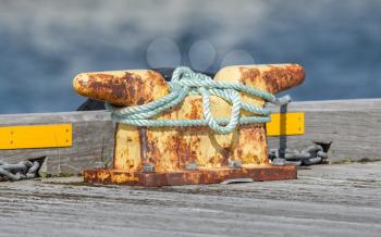 Metal bollard, many ropes on a dock
