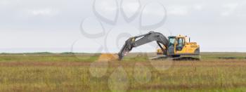 Yellow digger working in a field in Iceland
