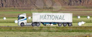 White trruck driving through a rural area - National