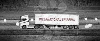 White trruck driving through a rural area - International shipping