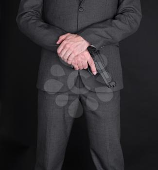 Man in suit with gun, isolated on black