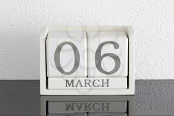 White block calendar present date 6 and month March on white wall background