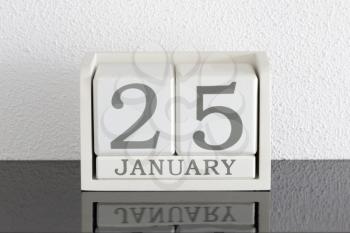 White block calendar present date 25 and month January on white wall background