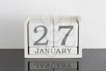 White block calendar present date 27 and month January on white wall background