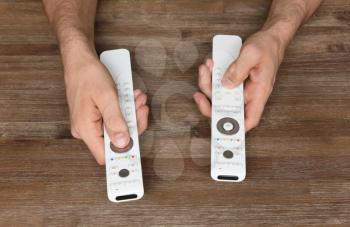 Man holding two white remotes in his hand - Take control!