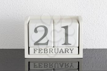 White block calendar present date 21 and month February on white wall background