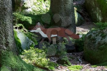 Education in the forest - wooden fox waiting to be spotted by children - Selective focus