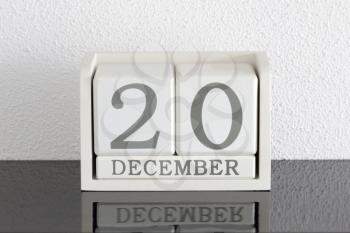 White block calendar present date 20 and month December on white wall background