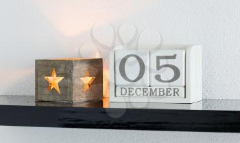 White block calendar present date 5 and month December on white wall background