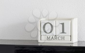 White block calendar present date 1 and month March on white wall background