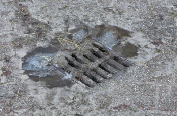 Steel manhole cover or metal sewer on a street in the Netherlands - Winter