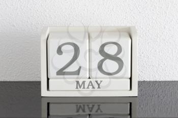 White block calendar present date 28 and month May on white wall background