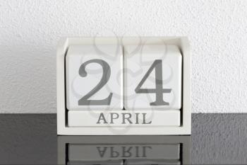 White block calendar present date 24 and month April on white wall background