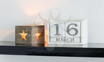 White block calendar present date 16 and month March on white wall background