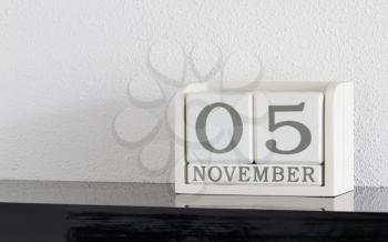 White block calendar present date 5 and month November on white wall background