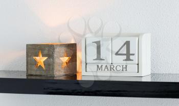White block calendar present date 14 and month March on white wall background