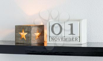 White block calendar present date 1 and month November on white wall background
