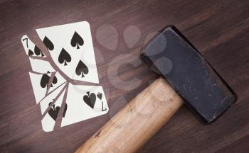 Hammer with a broken card, vintage look, seven of spades