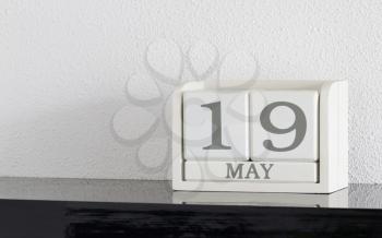 White block calendar present date 19 and month May on white wall background