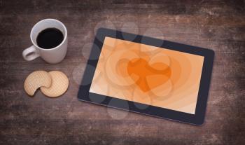 Heart shape backgound on a tablet - Concept of love - orange