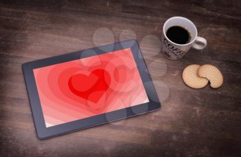 Heart shape backgound on a tablet - Concept of love - red