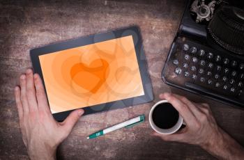 Heart shape backgound on a tablet - Concept of love - orange