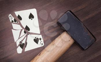 Hammer with a broken card, vintage look, five of spades