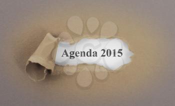 Text appearing behind torn brown envelop - Agenda 2015