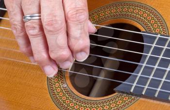 Close up on an old woman's hand playing guitar