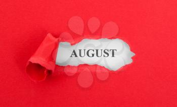 Text appearing behind torn red envelop - August