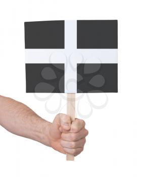 Hand holding small card, isolated on white - Flag of Cornwall