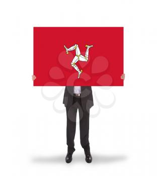 Smiling businessman holding a big card, flag of Isle of Man, isolated on white