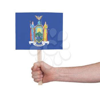 Hand holding small card, isolated on white - Flag of New York