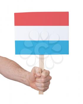 Hand holding small card, isolated on white - Flag of Luxembourg